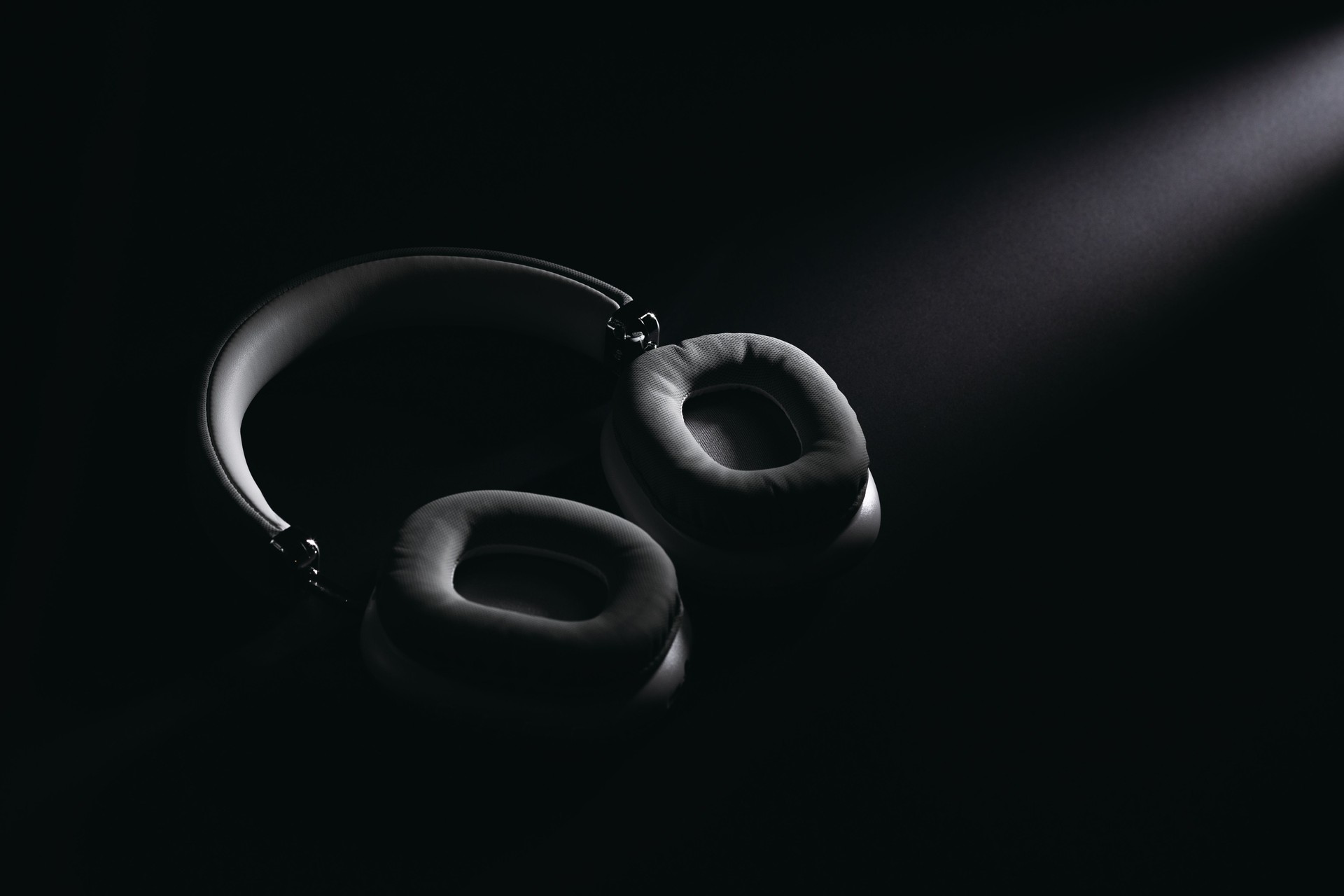 Sleek black over-ear headphones in dramatic spotlight